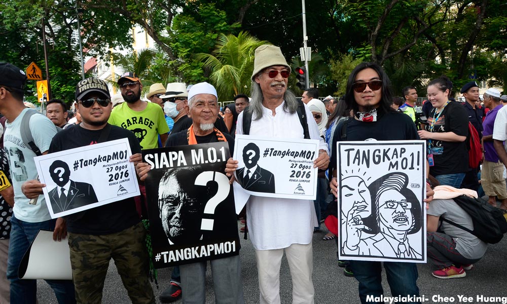 Red shirts seek retribution on TangkapMO1; KJ silent on royal information