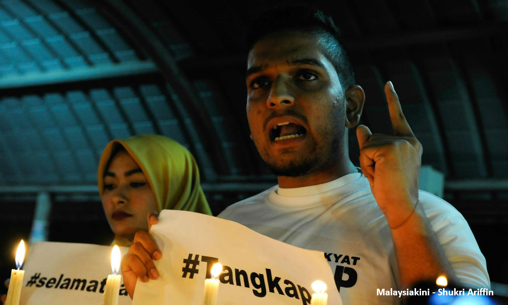 Students flash protest placards at Najib's entourage