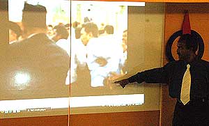 sivakumar pointing at video footage of suspected gun being carried into perak state assembly chaos incident 130509