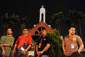 Muslim volunteers stand guard at mid-night in front of St. James Church to avert any attack on the church in  KL 1