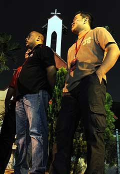 Muslim volunteers stand guard at mid-night in front of St. James Church to avert any attack on the church in KL 2