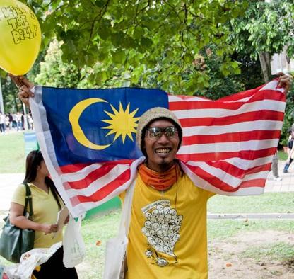 klcc anti-assembly bill picnic protester with malaysian flag