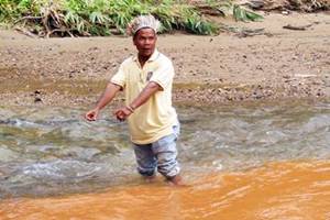 Gua Musang - angah muda stand in river with mixed water