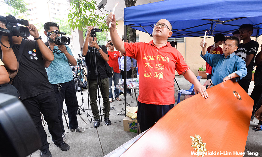 Coffin for DAP MP, supporters react with 'RM2.6b' placards