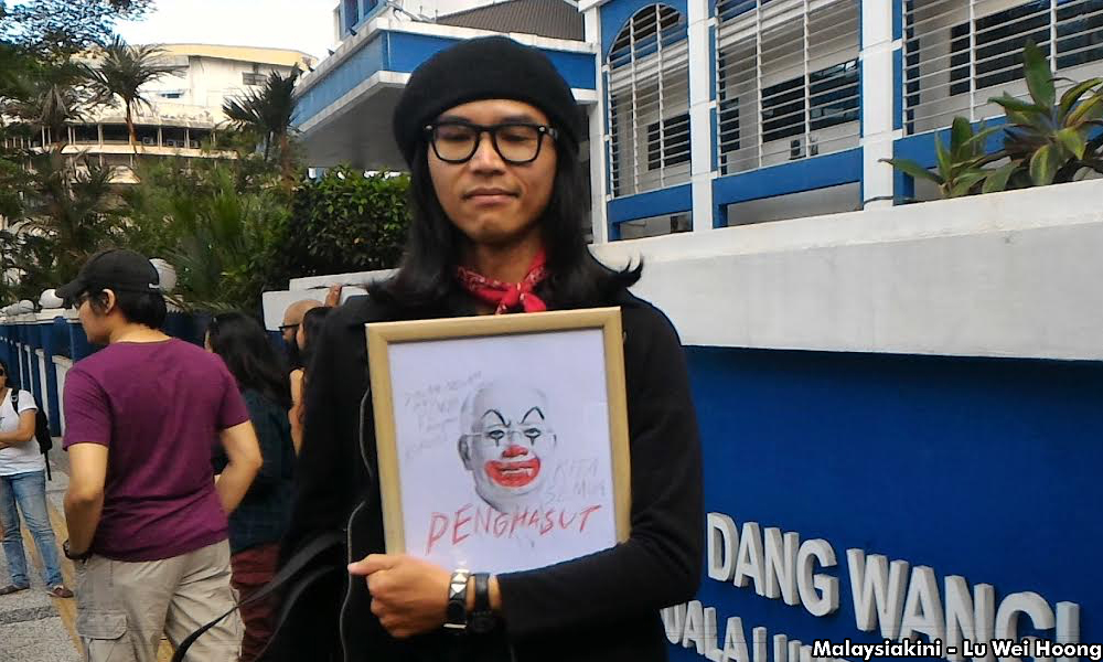 Fahmi brings 'clown Najib' to police station after being summoned